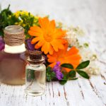 a cet emplacement s'affiche des fioles d'huiles essentielles avec des plantes et des fleurs